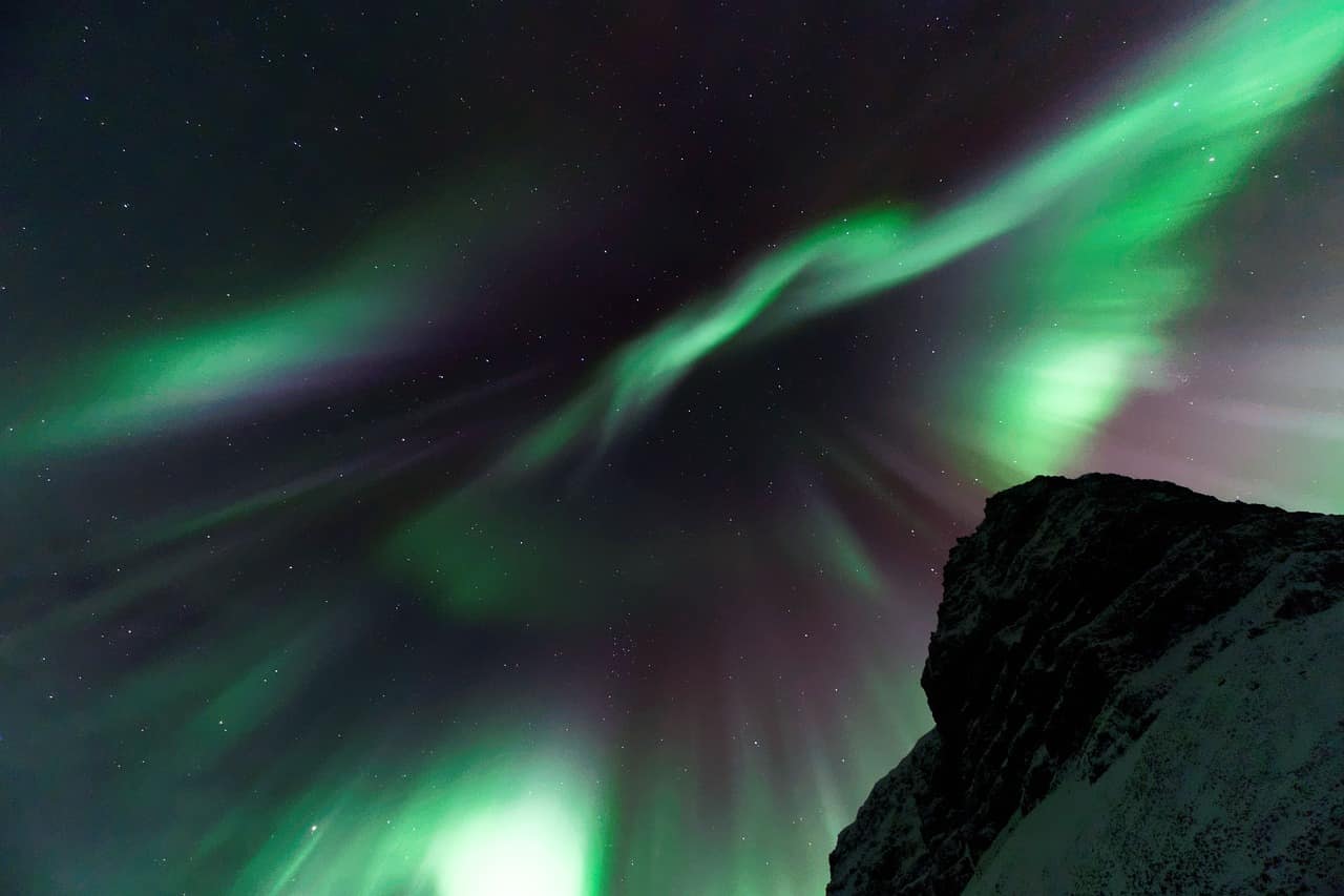 Green northern lights swirling over Iceland at night
