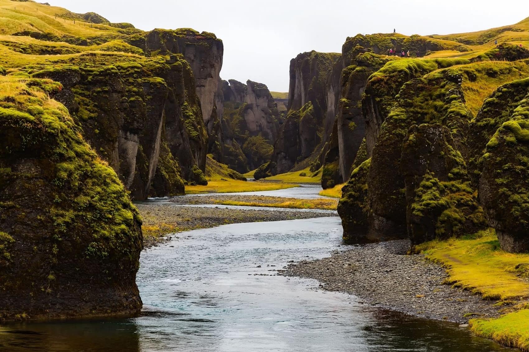 The mossy walls of Fjadrargljufur canyon with the river winding through it